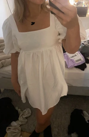 Vit puffärm klänning med öppen rygg - Supersöt vit kort klänning med puffärmar och fyrkantig urringning samt öppen rygg. Helt ny. Storlek 36