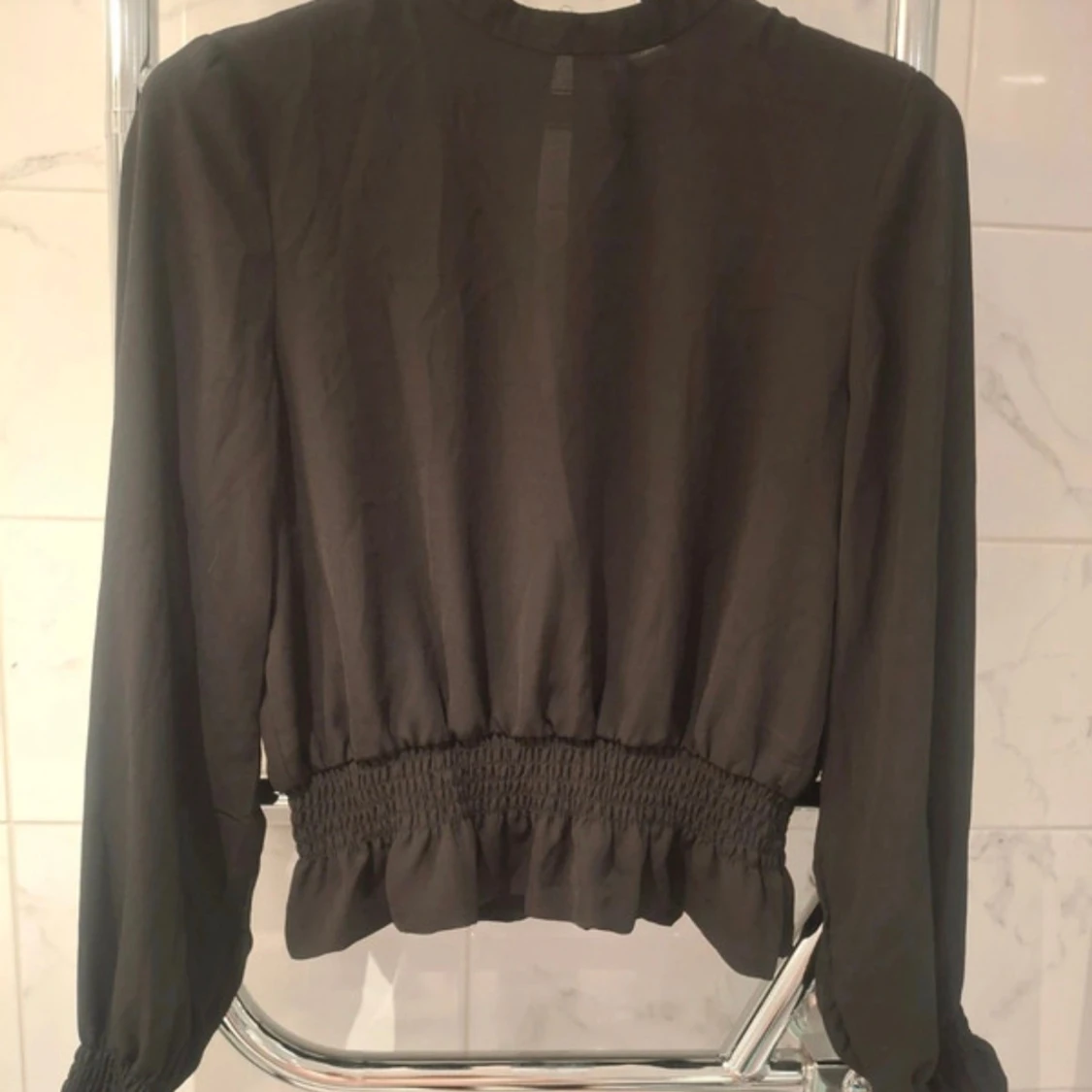 Svart blus med smock och volang