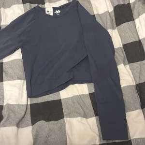 Mörkblå långärmad tröja från 157 - En stilren mörkblå långärmad tröja från 157 med rund halsringning. Tröjan är tillverkad i ett mjukt och stretchigt material, passad till träning. Passar dig som gillar en enkel och clean stil till träningspasset.