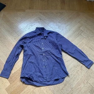 Blårutig skjorta från Polo Ralph Lauren - Snygg blårutig skjorta från Polo Ralph Lauren med klassisk krage och knappar framtill. Skjortan har lång ärm och är tillverkad i mjuk bomull. Perfekt för dig som gillar stilrena och tidlösa plagg med en preppy vibe.