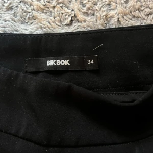 Svarta vida kostymbyxor Bik Bok - Svarta kostymbyxor från Bik Bok i storlek 34. 