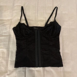 Svart korsett topp!! - Säljer denna jättesnygga svarta korsetttopp som är perfekt nu till halloween. Super bra skick, inga defekter. Skriv för fler frågor.
