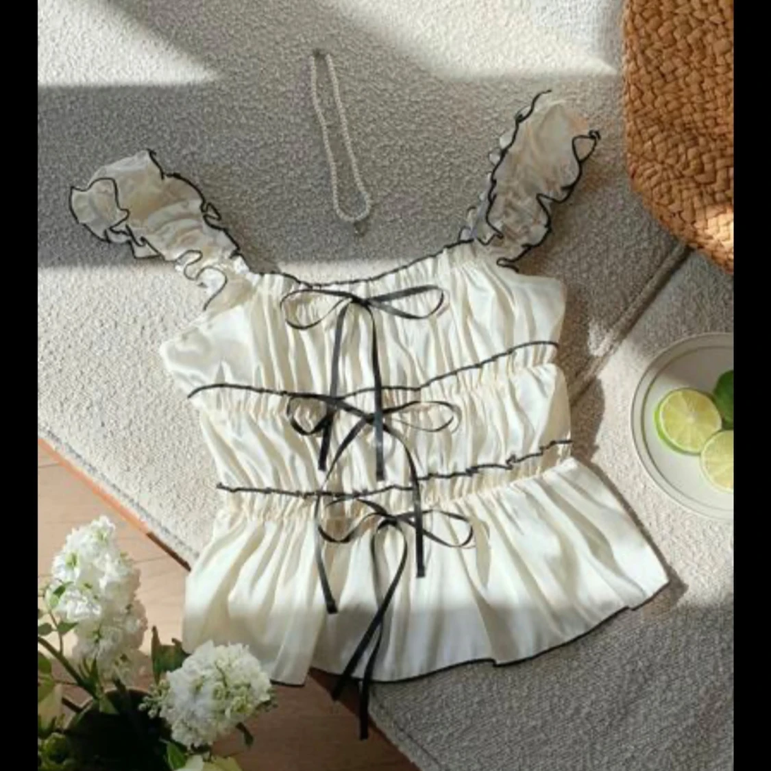 Vit satinlinnetopp med volang och snörning