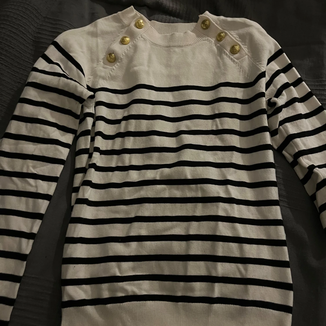 Randig vit och svart tröja med guldknappar