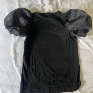 Svart topp med puffärmar - Snygg svart topp med stora puffärmar.