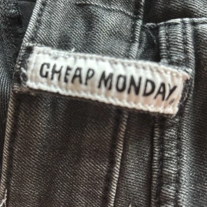 Svarta bootcut jeans Cheap Monday - Svarta jeans från Cheap Monday i bootcut-modell. Jeansen har klassisk femficksdesign, låg midja och är tillverkade i en stretchig denimblandning av bomull och elastan. Snyggt slitna detaljer och markerade sömmar ger en cool vibe.