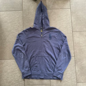 Blå hoodie från Polo Ralph Lauren Barn XL/Herr S) - Säljer en blå zip  hoodie från Polo Ralph Lauren i barnstorlek XL vilket motsvarar herr S. Tröjan är i gott skick.