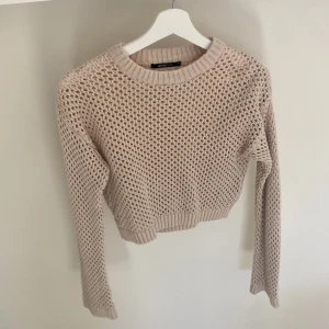 Beige stickad tröja från Gina Tricot - Säljer en beige stickad tröja från Gina Tricot i storlek XS. Tröjan har ett grovmaskigt, luftigt mönster och ribbade muddar vid hals, ärmslut och nederkant. Perfekt för lager-på-lager och snygg till både jeans och kjol.