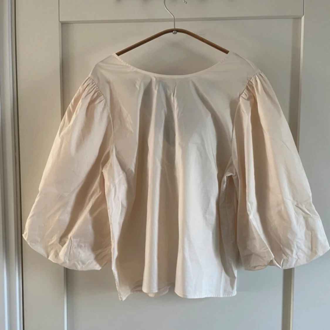 Beige blus med puffärmar och svart rosett - 1