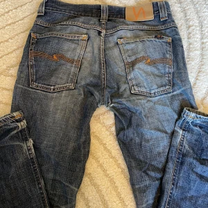 Lågmidjade jeans från Nudie Jeans Co - Raka lågmidjade jeans från Nudie Jeans Co med snygga fickor. Jag har använd dem mycket och de är köpa second hand. Därför är de slitna och har ett litet hål i grenen. Jag diskuterar gärna pris. Men det går såklart att laga om man kan sy🌸💕