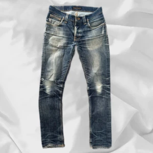 Nudie Grim Tim - Stört snygga Nudie Jeans i modellen Grim Tim, strlk 31/32 med en fet wash och snygg slitning på knät – enkla att matcha och sköna att bära. Ett stilrent val, noggrant utvalt med omsorg av AM Clothing.  📩 Frågor? Hör gärna av dig! 📲 Följ oss här på Plick för fler uppdateringar. ♻️ Tack för att du handlar mer hållbart med AM Clothing!