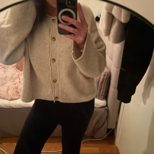Beige kofta från Pull&Bear, M - Mysig beige kofta från Pull&Bear i storlek M. Koftan har en loose passform, långa ärmar och knappar framtill. Tillverkad i ett mjukt stickat material som passar perfekt för kyligare dagar.