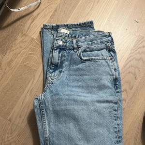  raka jeans från Gina - Säljer ett par klassiska ljusblå jeans från Levi's med raka ben och femficksmodell. Jeansen har normal passform och är tillverkade i slitstarkt denimtyg. Perfekta för en avslappnad och tidlös look.