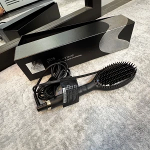 ghd Glide Smoothing Hot Brush - Ghd Glide Smoothing Hot Brush.  Detta är en professionell värmeborste designad för att snabbt och enkelt tämja och släta ut torrt hår.  Den använder keramisk teknologi med jonisator för att minimera frissighet och håller en optimal stylingtemperatur på 185 °C för att skydda håret.  Borsten har en kombination av korta och långa borststrån med hög densitet, vilket gör det möjligt att styla större sektioner av håret och nå ända ner till rötterna för en slät och glansig finish.  Endast provad!!!