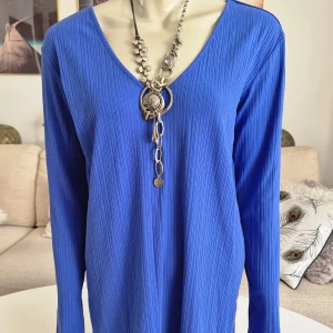 Lång blå långärmad topp * stl M * Monki - Blå lång, långärmad tröja med ett ribbat mönster. * Slitsar i ärmar samt i sidorna.  * V-formad nack och halsringning. * Nyskick. * Mått: - Armhåla till armhåla: ca 50 cm * Axel till ryggslut: ca 76 cm * Polyester, viskos, elastan.  Förstora bilderna då de ingår i beskrivningen.  Djur och rökfritt hem. Se gärna mina övriga annonser.  