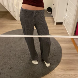 Randiga grå mjukisbyxor från 157 XS - Superbekväma grå mjukisbyxor från 157 i storlek XS. Byxorna har smala vita ränder, dragsko i midjan och ett loose fit med raka ben. Perfekta för chill dagar hemma eller när du vill vara extra comfy.
