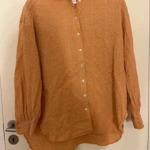 Persikofärgad The Shirt Factory skjorta - - The shirt factory                                                          - Storlek 36/S                                                                  - Mycket bra skick                                                        Väldigt fin periskofärgad skjorta som är perfekt att både ha på sig med en tröja eller ett linne under och ha skjortan öppen eller helt uppknäppt. Svarar gärna på frågor som bättre bilder eller något annat🧡