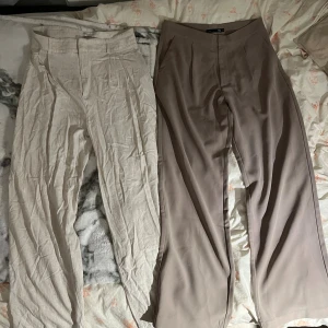 Beige linnebyxor & bruna kostymbyxor - Två par byxor: ett par ljusbeige linnebyxor med hög midja och ett par bruna kostymbyxor med rak och vid passform. Båda har klassisk stängning framtill och neutrala färger som är lätta att matcha.