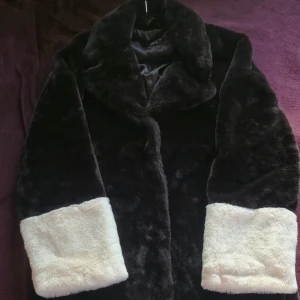 Svart och vit fuskpälsjacka Gina Tricot - Stl M - Säljer en fluffig pälsjacka från Gina Tricot i storlek M. Jackan är svart med breda vita muddar och vit nederkant, har en stor krage och är helfodrad. Perfekt för dig som vill ha en statement piece med skön oversized känsla. Använd vid ett tillfälle.