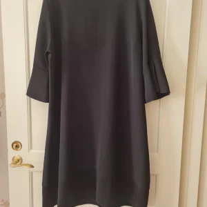 Klänning från Pronto Moda strl XL - Elegant svart klänning från Pronto Moda i en bekväm polyesterblandning. Klänningen har trekvartsärmar och en rak passform. Storlek XL. Kan hämtas i Vallentuna.