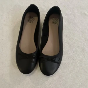 Svarta ballerinaskor med rosett - Säljer mina svarta ballerina skor med rosett, dem är i storlek 38 och super bekväma. Aldrig använt dem!! Köp nu jag postar snabbt!!💕💕