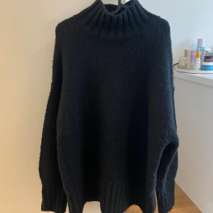 Svart stickad polotröja - Mysig svart stickad polotröja med oversized passform och bred ribbad krage. 