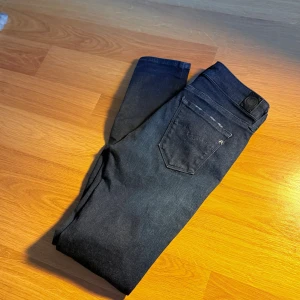 Replay Mörkblå Jeans - Snygga mörkblå jeans från Replay med klassisk femficksdesign. Jeansen har en diskret tvättad look, silverfärgade nitar och logotypdetalj vid fickan. Perfekta för dig som gillar stilrena och tajta jeans.