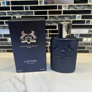 Parfums de Marly Layton 125ml - Lyxig och modern Eau de Parfum från Parfums de Marly. Layton kommer i en stilren 125 ml flaska och är tillverkad i Frankrike. Perfekt för dig som vill sticka ut med en exklusiv doft från ett trendigt parfymhus.