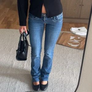 Blå bootcut jeans från LTB - Snygga blå denimjeans från LTB med bootcut passform och låg midja. Jeansen har klassiska fem fickor, dragkedja och knapp framtill. Materialet är mjukt och stretchigt jeans, perfekt för en cool och avslappnad look. Storlek 25/36
