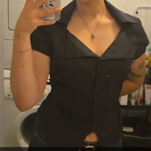 Svart bomulls skjorta - Oanvänd. Figursydd och har ett band i bak så man kan justera midjan