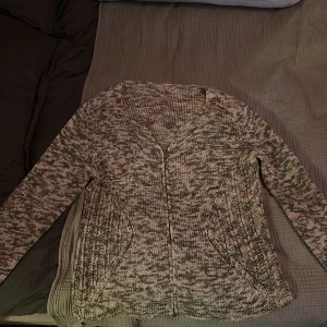 Grå/grön och vit stickad kofta med dragkedja - Stickad kofta med hel dragkedja framtill. Koftan har lång ärm, två sneda fickor och är något oversize (jag är 175)