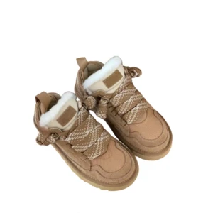 Beige boots med fuskpäls och snörning - Säljer ett par beige boots med platt sula och rund tå. Skorna har snörning med mönstrade band och är fodrade med vit fuskpäls för extra värme. Perfekta för kalla dagar och har en chunky look som är riktigt trendig.