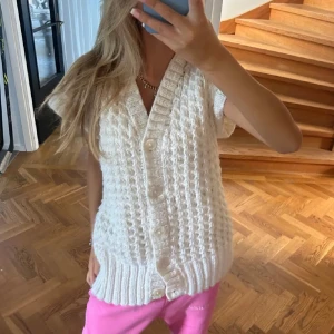 Vit stickad väst med knappar - Superfin vit stickad väst med grovt mönster och v-ringning. Västen har bred ribbad kant nedtill och stängs med stora knappar framtill. Köpt här på plick så vet tyvärr inte märket❣️