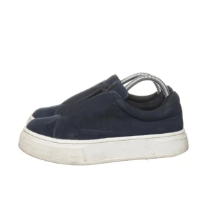 Mörkblå Eytys  - Stilrena mörkblå slip-on Eytys sneakers med tjock vit platt sula. Skorna har en minimalistisk design utan snörning och är perfekta för en avslappnad streetstyle-look. Ovandelen är i textil och sulan är i gummi för extra komfort. 