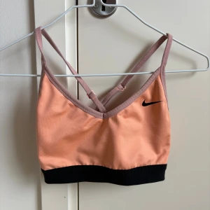Aprikos sport bh från Nike - Sport bh från Nike. Den är använd men sparsamt och tagit väl hand om den så i fint skick. Skulle säga att den passar xs även om storleken är S. Djur och rökfritt hem. Vid snabb affär kan jag tänka mig att sänka priset.  