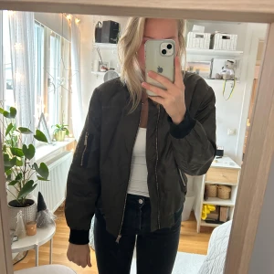 Grön bomberjacka  - Olivgrön bomberjacka med svarta muddar från Philosophy Republic Clothing. I storlek M. Mycket fint skick!! 