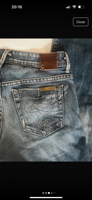 Blå bootcut jeans från Armani Exchange - Snygga blå jeans från Armani Exchange med bootcut passform och coola detaljer i form av silverfärgade nitar på bakfickorna. Låg midja storlek US 4 EU 36