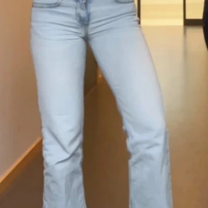 Ljusblå bootcut jeans från Levis - Säljer ett par ljusblå jeans från Levis med klassisk bootcut passform och låg midja. Jeansen har fem fickor, slitna detaljer och är tillverkade i jeansmaterial. Perfekt för dig som gillar retrovibbar och avslappnad stil. Finns dock ett hål i ena bakfickan.