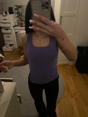 Lila linnetopp från BikBok - Säljer en lila ärmlös linnetopp från BikBok i storlek S. Toppen har en klassisk rund halsringning och är gjord i mjuk bomull, perfekt för en chill och enkel look. Snygg att styla med jeans eller kjol för en avslappnad vibe.  Aldrig använd 