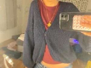 Mörkblå stickad kofta - Mysig och oversized mörkblå stickad kofta med v-ringning och en enkel knapp framtill. Koftan har långa ärmar och en avslappnad passform, perfekt att slänga på sig över en t-shirt eller linne.