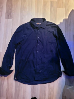 Morris skjorta  - En riktig fräsch Morris skjorta som jag inte kan ha längre, storlek XL men jag tror det är barn för den sitter som en M - L. Använd 5 gånger i somras. Den har en riktigt skönt material typ mocha, Har varit trasig i en av knapparna men det är löst med sytråd och pyttelite lim 