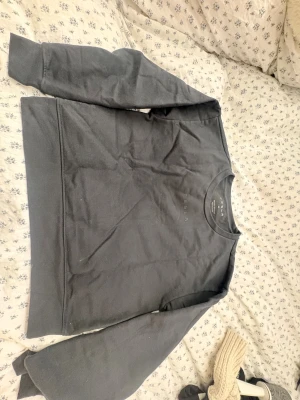 Mörkgrå sweatshirt från Tesla - Säljer en stilren mörkgrå sweatshirt från Tesla i storlek M. Tröjan har rund hals, långa ärmar och diskret Tesla-logga på bröstet. Materialet är mjuk bomull och polyester, perfekt för chill dagar. Enkel och clean design som funkar till jeans eller joggers.