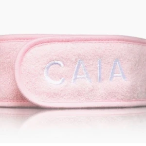 Rosa frotté diadem från CAIA - Säljer ett mjukt och bekvämt rosa diadem från CAIA i frotté med broderad logga framtill. Perfekt för att hålla håret borta vid sminkning eller hudvård. Justerbar med kardborre för bästa passform.