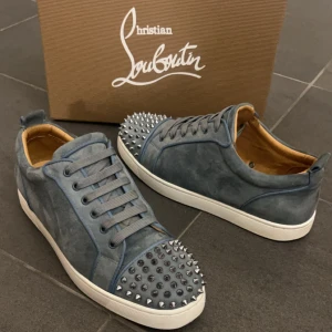 Christian Louboutin skor - Christian Louboutins i ljusblå nyans.              Storlek: 44.  Skick: 9/10 - Skorna är lätt använda. Pris: 4399 SEK.Vad som ingår: två dustbags, originalpåsar, tre nitar, extra skosnören i en mörkare nyans samt originalbox.