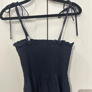 Marinblå topp från SHEIN - Säljer en marinblå topp från SHEIN i storlek XS. Toppen har knut band vilket gör de enkelt att justera hur högt/lågt man vill ha den.