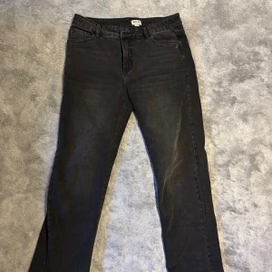 Svarta jeansbyxor från Madlady - Svarta lågmidjade jeansbyxor från Madlady med klassisk femficksdesign och lös passform. Jeansen har en något tvättad look och raka ben. Perfekta för dig som gillar en enkel och stilren vibe.