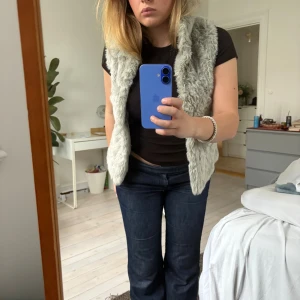 Ljusgrå fluffig pälsväst - Såljer en superfint väst. Går att stänga med knappar hela vägen upp. Superfin men snäppet för liten för mig vid bysten (för att stänga)