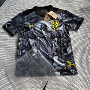 Brasilien Nike fotbollströja S - Unik Brasilien fotbollströja från Nike med detaljerat grafiskt tryck av Kristusstatyn och brasilianska symboler. Tröjan är kortärmad, har svart bas med inslag av grått och gult, samt Brasilien-emblem på bröstet. Tillverkad i lätt Dri-FIT material som andas.