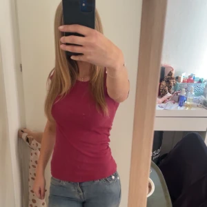 Mörkröd ribbad T-shirt - Säljer en mörkröd ribbad T-shirt med rund hals och korta ärmar. Toppen har en slim passform och är tillverkad i mjuk bomull,söt och basic