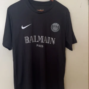 Svart fotbollströja - Svart fotbollströja med tryck på bröstet. Klassisk rund hals, korta ärmar och Swoosh på framsidan. Tillverkad i lätt och bekvämt material, perfekt för dig som gillar stilren sportlook.